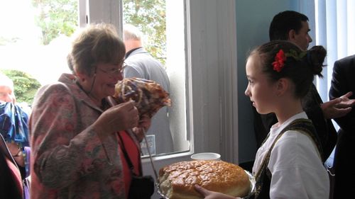 Picture 7 – At the cordial reception with bread and salt: Inge Morgenthaler and a young “New-Jarek” girl in the foyer of the town hall.